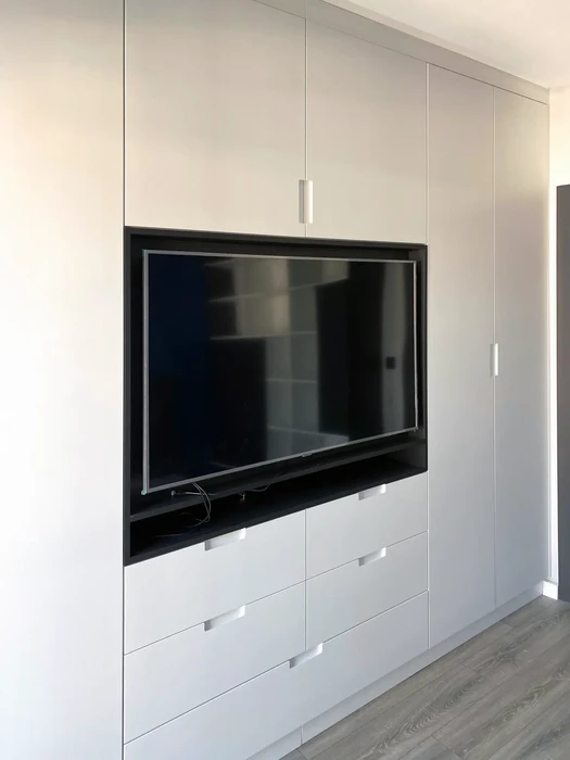 Intérieur résidentiel moderne avec meuble TV intégré dans une armoire sur mesure