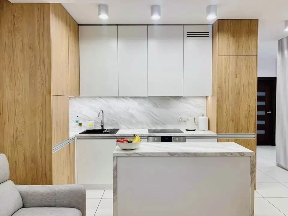 Cuisine moderne ouverte avec îlot central en marbre blanc veiné