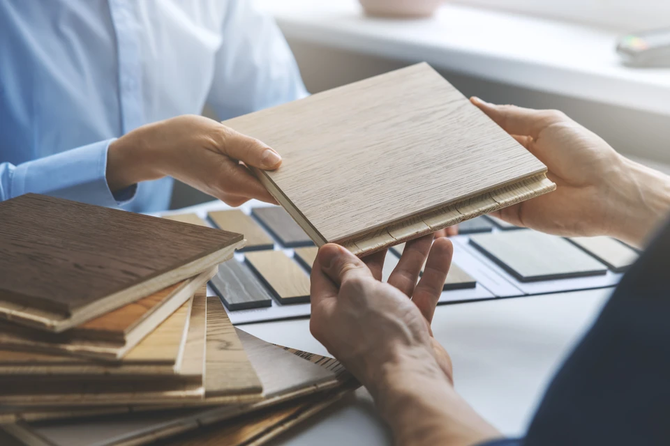 Scène d'intérieur professionnel où deux personnes examinent des échantillons de matériaux