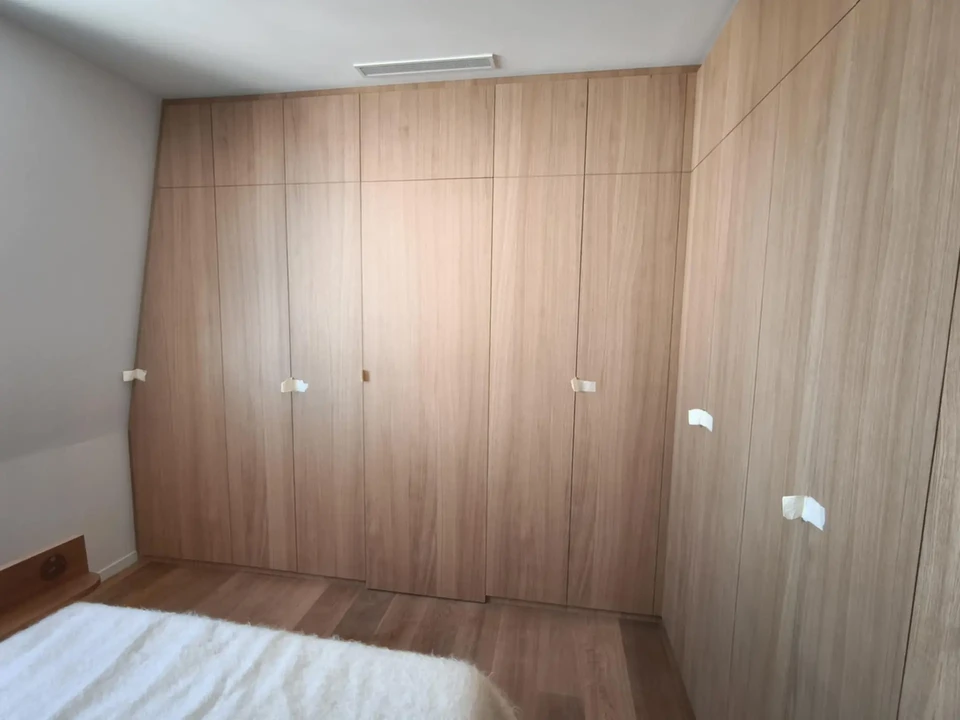 Intérieur minimaliste avec fauteuil gris moderne sur pieds en bois clair, coussins assortis