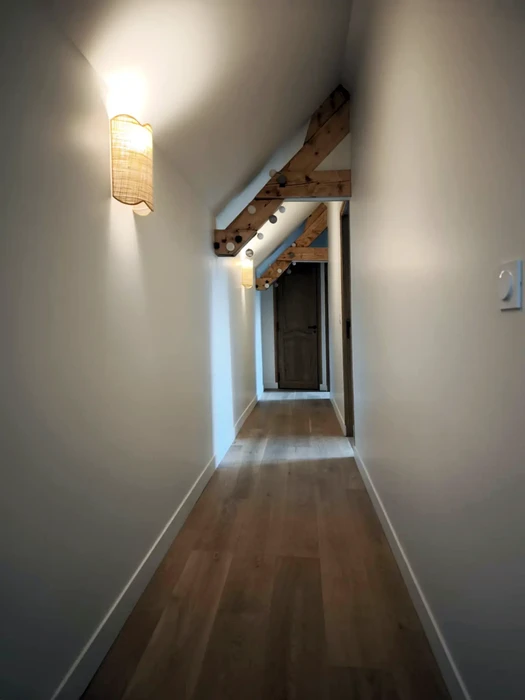 Intérieur moderne avec mur en panneaux bois massif à motifs diagonaux, canapé capitonné beige et suspensions sphériques blanches à détails dorés