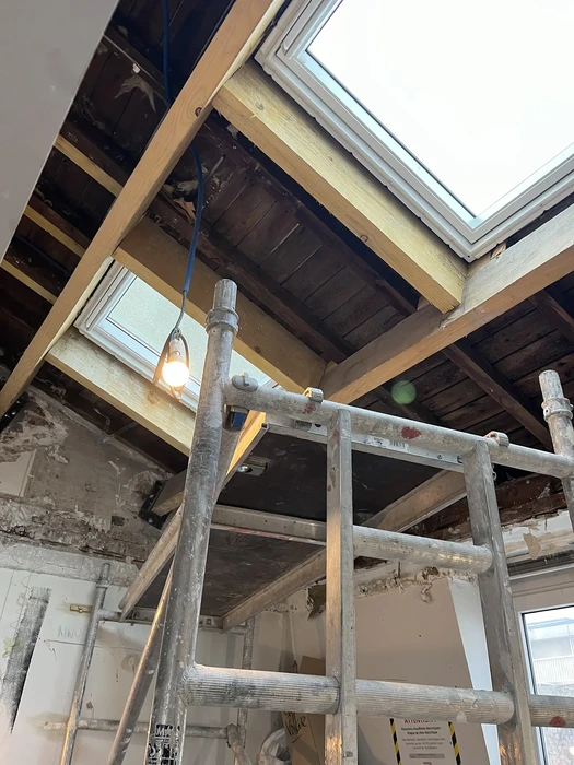 Cuisine moderne intégrée avec îlot central, mobilier en bois naturel et façades blanches laquées