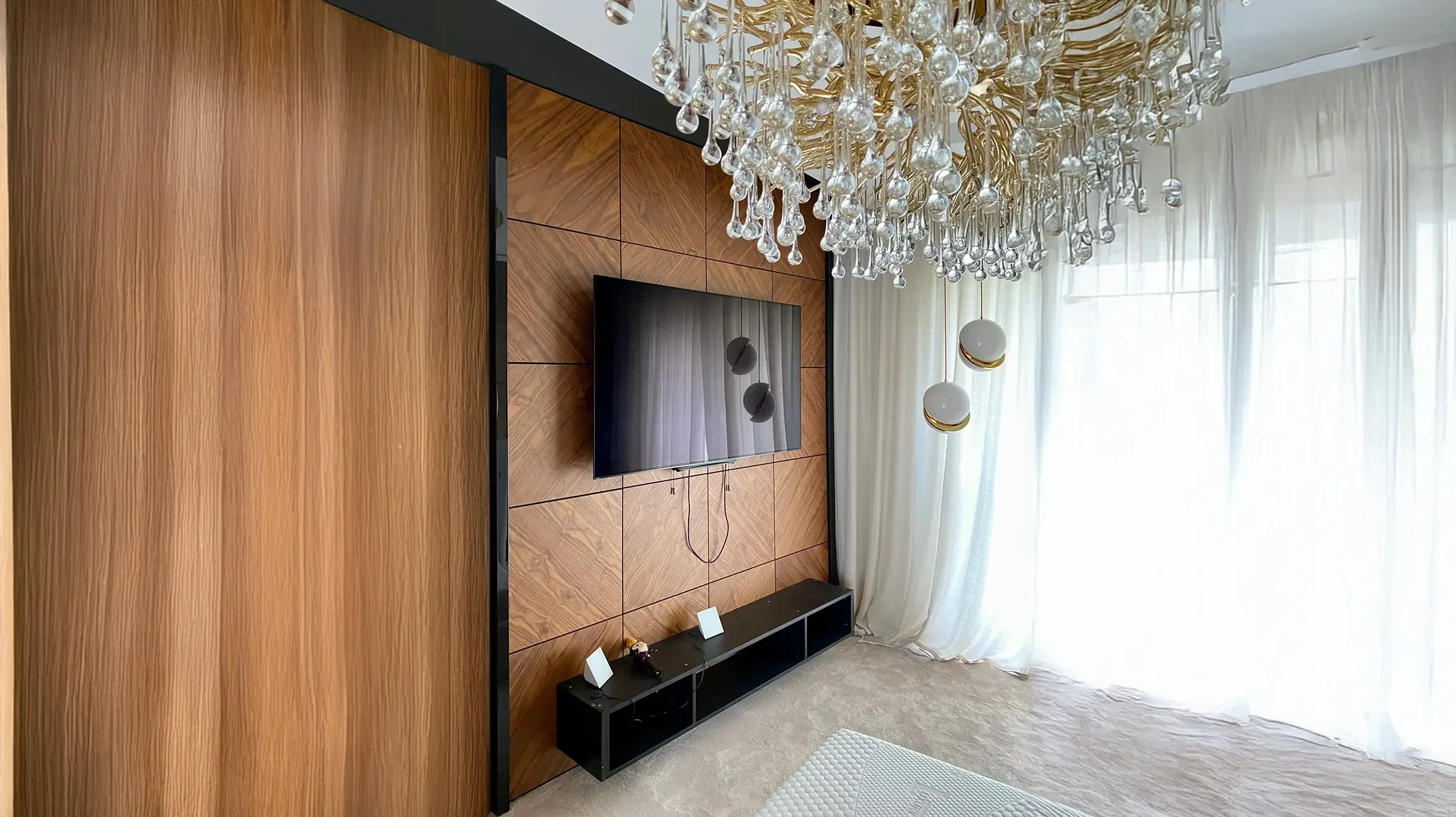 Salon spacieux avec cheminée en marbre blanc et manteau décoratif, murs peints en vert olive, plafond blanc avec poutres apparentes et éclairage encastré