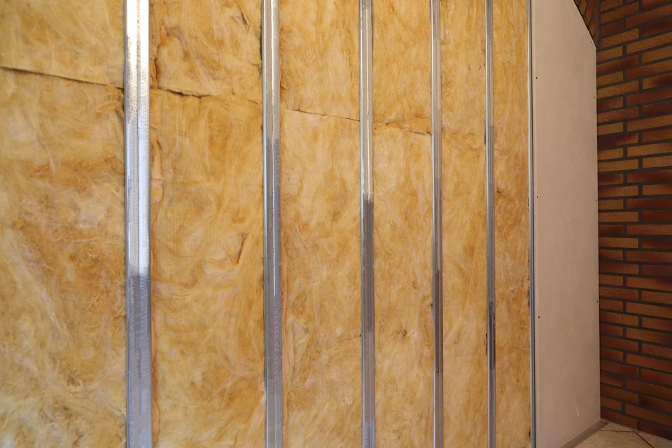 Un salon serein et minimaliste avec un canapé blanc moelleux orné de coussins neutres et d'une couverture douillette